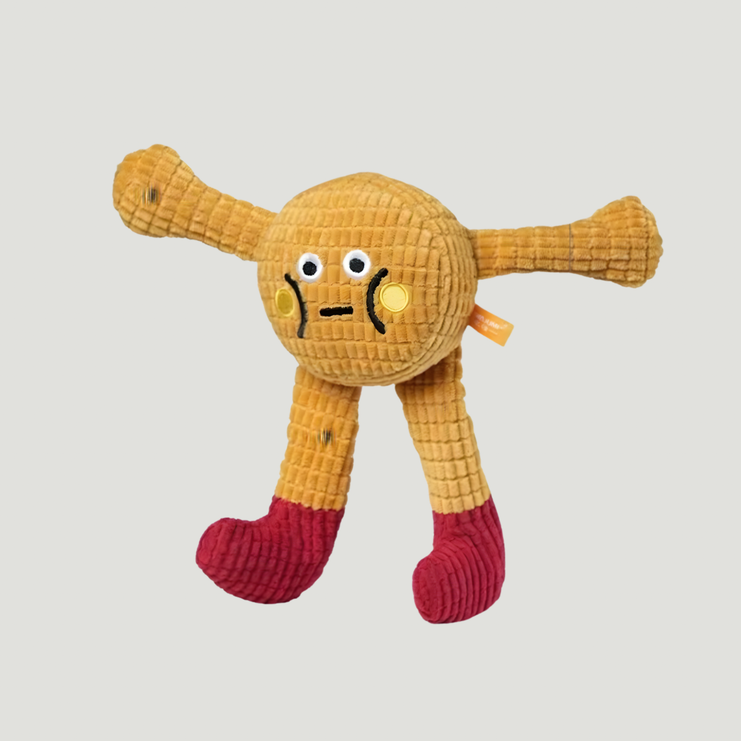 Yellow plush toy with a face on a light gray background